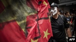 Seorang pria mengenakan topeng peretas anonim dalam aksi dukungan terhadap pembangkang pemerintah China, Li Wangyang, di Hong Kong, pada 10 Juni 2012. (Foto: AFP/Philippe Lopez)