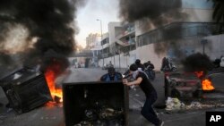 Anti-government protesters block a main highway by a garbage containers and burned tires, during ongoing protests against the Lebanese government, in Beirut, Lebanon, Nov. 4, 2019. 