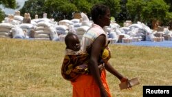 A Zimbabwean collects her monthly rations of food aid from Rutaura Primary School in the Rushinga district of Mount Darwin, north of Harare, March 7, 2013. 