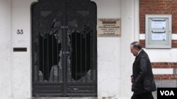 Seorang pria melewati pintu masjid Reda yang rusak di Brussels, Belgia (13/3).