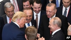 លោក​ប្រធានាធិបតី ដូណាល់ ត្រាំ ចាប់​ដៃ​ជាមួយ​នឹង​លោក​ប្រធានាធិបតី Vladimir Putin (រូប​ស្តាំ) នៅ​ក្នុង​ពេល​ចូលរួម​ក្នុង​កិច្ចប្រជុំ​កំពូល G-20 ក្នុង​ក្រុង Osaka ប្រទេស​ជប៉ុន កាលពី​ថ្ងៃទី២៩ ខែមិថុនា ឆ្នាំ២០១៩។