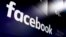 FILE- The logo for Facebook appears on screens at the Nasdaq MarketSite in New York's Times Square, March 29, 2018. 