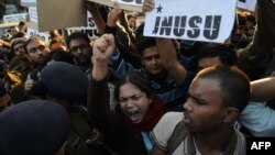 Indian residents hold placards and chant slogans as they take part in a protest against the alleged rape of a passenger by a driver working for the Uber taxi company in New Delhi, Dec. 7, 2014. 