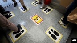 Social distancing stickers are viewed in an elevator at a shopping building Monday, Sept. 28, 2020, in Tokyo.