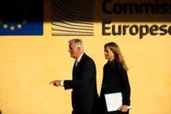 European Union chief Brexit negotiator Michel Barnier, left, walks to a meeting about Brexit at the EU headquarters in Brussels, Oct. 28, 2019.