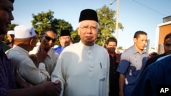 FILE - Malaysian Prime Minister Najib Razak arrives for a Ramadan breakfast at a mosque in Semenyih outside Kuala Lumpur, Malaysia, July 5, 2015. Razak was cleared of any wrongdoing Tuesday in a huge financial scandal.