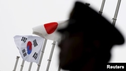 Bendera Jepang dan Korea Selatan berkibar di depan Kedutaan Besar Korea Selatan di Tokyo, Jepang 22 Juni 2015. (Foto: Toru Hanai/Reuters)