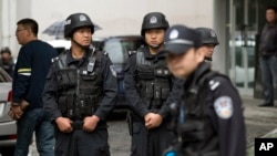 Armed policemen stand guard near the site of an explosion in Urumqi, northwest China's Xinjiang region, May 22, 2014.