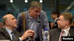 European Economic and Financial Affairs Commissioner Pierre Moscovici (L) chats with Greece's Finance Minister Euclid Tsakalotos (C) and European Commission Vice-President Valdis Dombrovskis during a Euro zone finance ministers meeting, May 24, 2016.