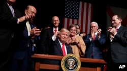 Presiden Donald Trump mengepalkan tinjunya setelah menandatangani perintah eksekutif terkait kebijakan tentang Kuba, hari Jum’at, 16 Juni 2017 di Miami (foto: AP Photo/Evan Vucci)