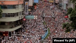 CHINA - Protesters march along a downtown street against the proposed amendments to an extradition law in Hong Kong Sunday, June 9, 2019