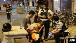 واکنش یک زن جوان در تل ابیب با دو کارمند امداد رسان پس از حملات راکتی گروه حماس بر اسراییل