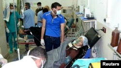 A woman affected by what activists say was a gas attack on the town of Telminnes breathes through an oxygen mask at Bab al-Hawa hospital, in Syria, April 21, 2014.