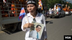 រូបឯកសារ៖ ស្ត្រី​ម្នាក់​កាន់​រូបភាព​លោក កែម ឡី ខណៈ​ពេល​ប្រជា​ពលរដ្ឋ​រាប់​ម៉ឺន​នាក់​ចូលរួម​ជូន​ដំណើរ​លោក​ កែម ឡី​ នៅ​ថ្ងៃ​អាទិត្យ​ ទី​២៤ ខែកក្កដា​ ឆ្នាំ២០១៦​។​