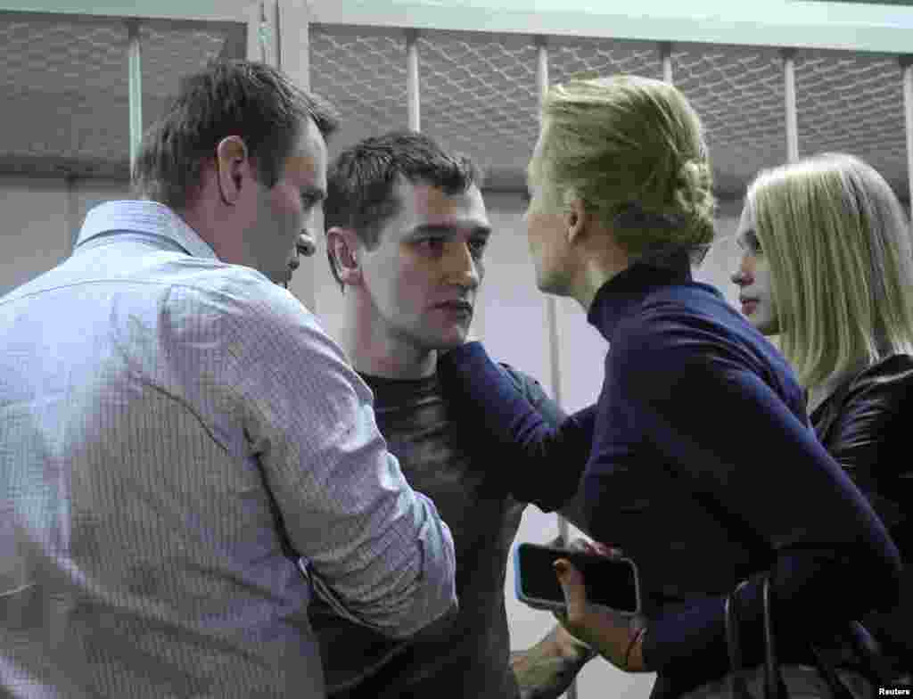 Alexei Navalny, Russian opposition leader and anti-corruption blogger, and his wife Yulia comfort Alexei's brother and co-defendant Oleg and his wife Victoria after hearing the court verdict in Moscow, Dec. 30, 2014.