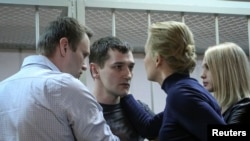 Alexei Navalny, aktivis politik dan blogger anti korupsi, beserta istrinya Yulia, terlihat bersama Oleg Navalny dan istrinya Victoria sesudah sidang pengadilan di Moskow, 30/12/2014. 