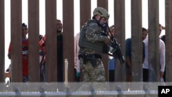 Seorang petugas Dinas Bea Cukai dan Perlindungan Perbatasan AS berjalan di sepanjang dinding perbatasan AS-Meksiko, tampak dari San Diego, California, 25 November 2018.
