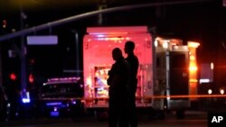 Two police officers stand outside an office building where a mass shooting occurred in Orange, Calif., March 31, 2021.