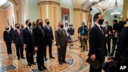 FILE - Democratic House impeachment managers stand before entering the Senate Chamber as they deliver to the Senate the article of impeachment alleging incitement of insurrection against former President Donald Trump, in Washington, Jan. 25, 2021.