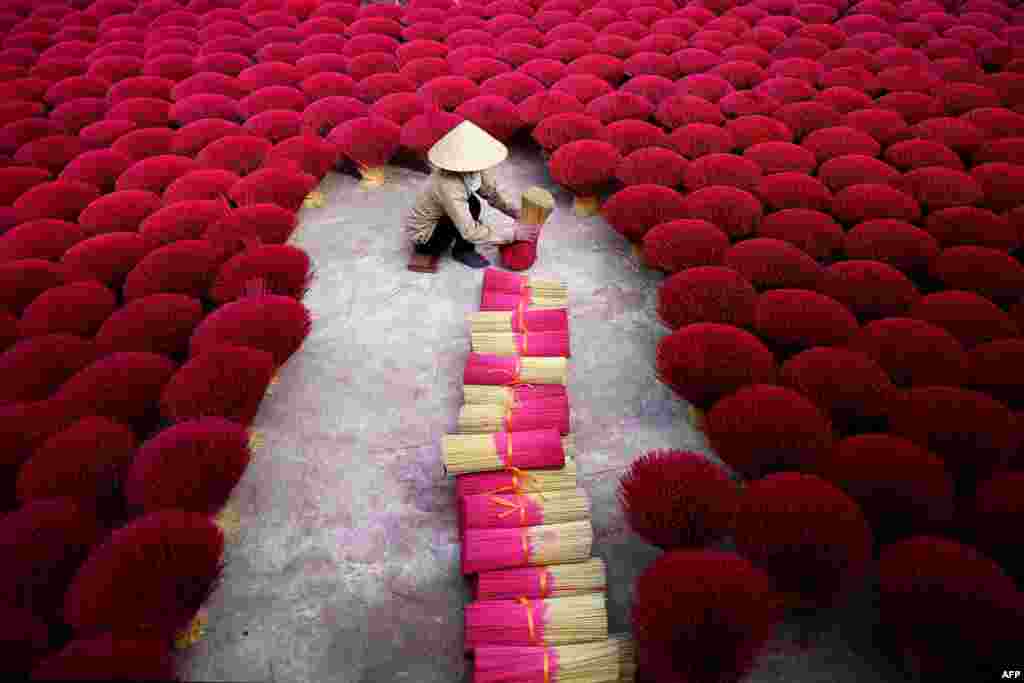 ស្រ្តី​ជនជាតិ​វៀតណាម​ម្នាក់​ប្រមូល​ធូប​នៅ​ក្នុង​ភូមិ Quang Phu Cau ជាយក្រុង​ហាណូយ។