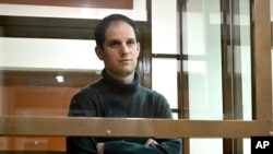 FILE - Wall Street Journal reporter Evan Gershkovich stands in a glass cage in a courtroom at the Moscow City Court, in Moscow, Russia, on Dec. 14, 2023. 