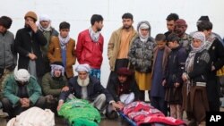 Afghans attend funeral of the family members of journalist Bismillah Adil Aimaq, who was shot dead in an unclaimed attack nearby Ghor on Jan. 1, in Ghor, western Afghanistan, Feb. 26, 2021. 