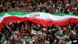 Iranian women cheer during a soccer match between their national team and Cambodia in the 2022 World Cup qualifier, Oct. 10, 2019.