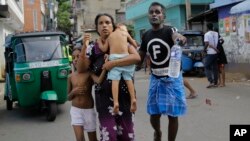 Sri Lankans living near St. Anthony's shrine run for safety after police found explosive devices in parked vehicle, which later exploded in Colombo, Sri Lanka, April 22, 2019.