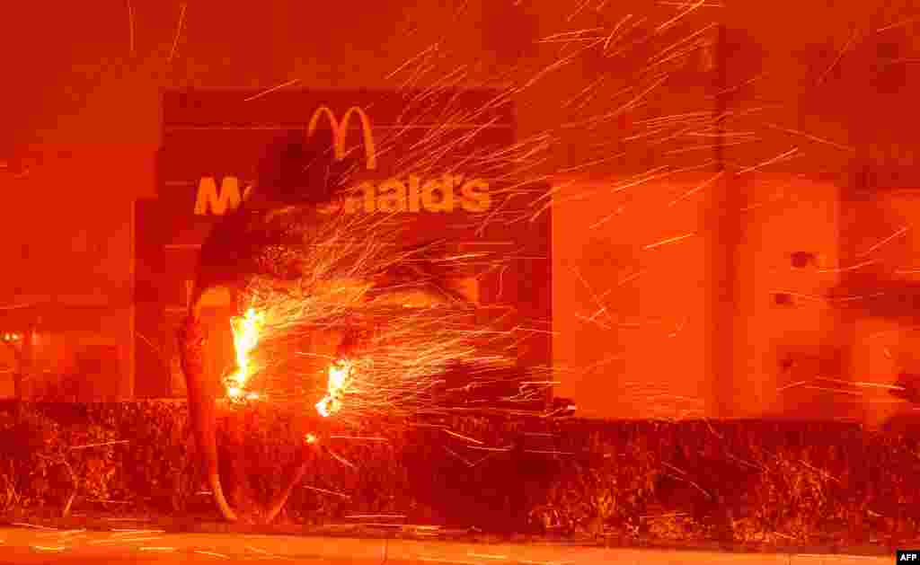 A McDonald&#39;s restaurant is showered in embers during the Eaton Fire in Pasadena, California, Jan. 7, 2025.&nbsp;A ferocious wildfire in a Los Angeles suburb devoured buildings and sparked panicked evacuations, as hurricane-force winds tore through the region. More than 200 acres (80 hectares) was burning in Pacific Palisades, a upscale spot with multi-million dollar homes in the Santa Monica Mountains. Across town, on the northern edge of Los Angeles, another fire broke out in Eaton Canyon, near Pasadena, quickly consuming 200 acres (81 hectares) later in the night, according to Angeles National Forest officials.