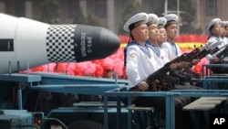 ARCHIVES - Des membres de la marine nord-coréenne sont assis devant un missile balistique lancé par un sous-marin lors d'une parade à Pyongyang, le 15 avril 2017.