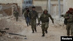  A rebel fighter runs with a weapon on the outskirts of the northern Syrian town of al-Bab, Syria, Jan. 26, 2017. 