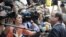 France's President Francois Hollande (R) talks to the media as he arrives at an informal EU leaders summit in Brussels, May 23, 2012.