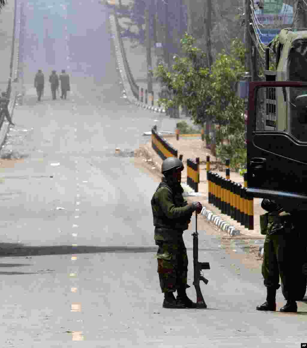 A Kenya Defense Forces soldier stands resting with his gun while others patrol on the empty road near the Westgate Mall in Nairobi, Sept. 25, 2013.&nbsp;