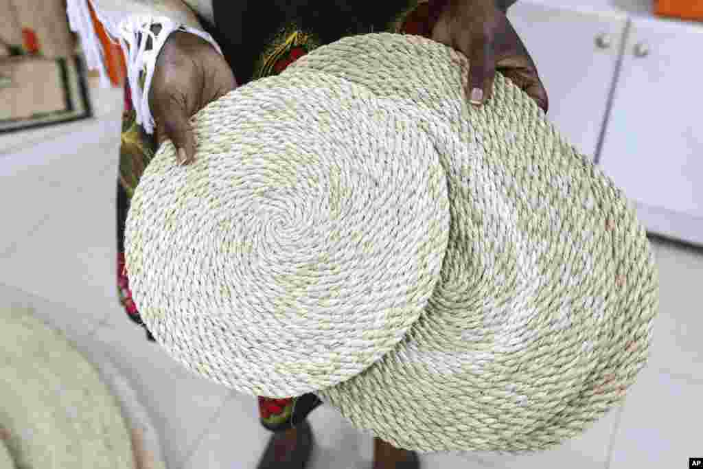 A woman displays banana fiber handmade table mats while at a TEXFAD showroom, in Kira, Wakiso District, Uganda, Sept. 20, 2023.