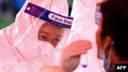 一位青岛医务人员正在给受试者做核酸检测。(资料图）