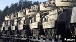 U.S. Bradley fighting vehicles that will be deployed in Latvia for NATO's Operation Atlantic Resolve wait to be unloaded in Garkalne, Latvia, Feb. 8, 2017.