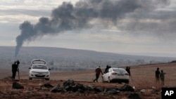 媒体在叙吕奇郊区山顶上观察叙利亚科巴尼战火