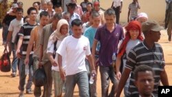 អ្នកនេសាទ​ដែល​ត្រូវ​បាន​ក្រុមចោរ​សមុទ្រ​ចាប់​ឃុំឃាំង​ប្រមាណ​ជាង​៤ឆ្នាំ ដើរ​ឡើង​យន្តហោះ ក្រោយពី​ពួកគេ​​ត្រូវ​បាន​ដោះលែង​នៅ​ក្នុង​ក្រុងGalkayo នៃ​ប្រទេស​សូម៉ាលី នៅ​ថ្ងៃ​អាទិត្យទី ២៣ ខែតុលា ឆ្នាំ២០១៦។ (រូបថត AP) 