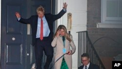 Britanski premijer i lider konzervativaca Boris Džonson napušta prostorije stranke sa svojom partnerkom Keri Sajmonds i njihovim psom Dilanon, u Londonu, 13. decembra 2019.