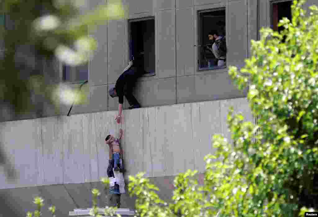 A boy is evacuated during an attack on the Iranian parliament in central Tehran.