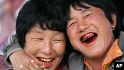 Women, their teeth red from chewing betel nuts, laugh at a vegetable market in Bhutanese capital Thimpu (October 2006 file photo)