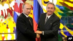 Presiden Kuba Raul Castro (kanan) menjabat tangan dengan Presiden Rusia Vladimir Putin di Istana Revolusi, Havana, Kuba (11/7).