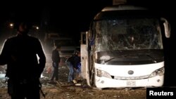 Police officers inspect the scene of a bus blast in Giza, Egypt, Dec. 28, 2018.