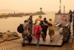 Evacuees board a landing craft to be ferried to the navy's HMAS Choules, Jan. 3, 2020, in Mallacoota, Victoria, Australia.