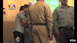 ប៉ូលិស​ និងមន្ត្រី​ពន្ធនាការ​ឈរនៅ​មុខសាល​សវនាការ​សាលាឧទ្ធរណ៍។​