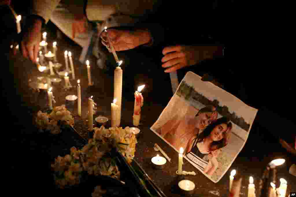 Candles sit in front of a picture of a victim at a vigil for those killed in the Ukraine plane crash, at the gate of Amrikabir University, in Tehran, Iran, Jan. 11, 2020.