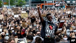 A man raises his fist as people gather in Berlin, Germany, Saturday, June 6, 2020, to protest against the recent killing of George Floyd by police officers in Minneapolis, USA, that has led to protests in many countries and across the US. A US…