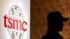 Seorang petugas keamanan berdiri di dekat logo Taiwan Semiconductor Manufacturing Co. Ltd (TSMC) di Taipei. (Foto: REUTERS/Pichi Chuang)