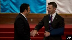 Presiden Guatemala Jimmy Morales berjabat tangan dengan Penjabat Menteri Luar Negeri AS Kevin McAleenan (kanan) di Istana Nasional di Guatemala City, Senin, 27 Mei 2019.
