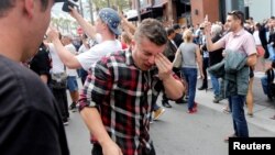 A man holds his face after being hit with pepper spray during a demonstration outside a campaign event for Republican presidential candidate Donald Trump in San Diego, Calif., May 27, 2016. 